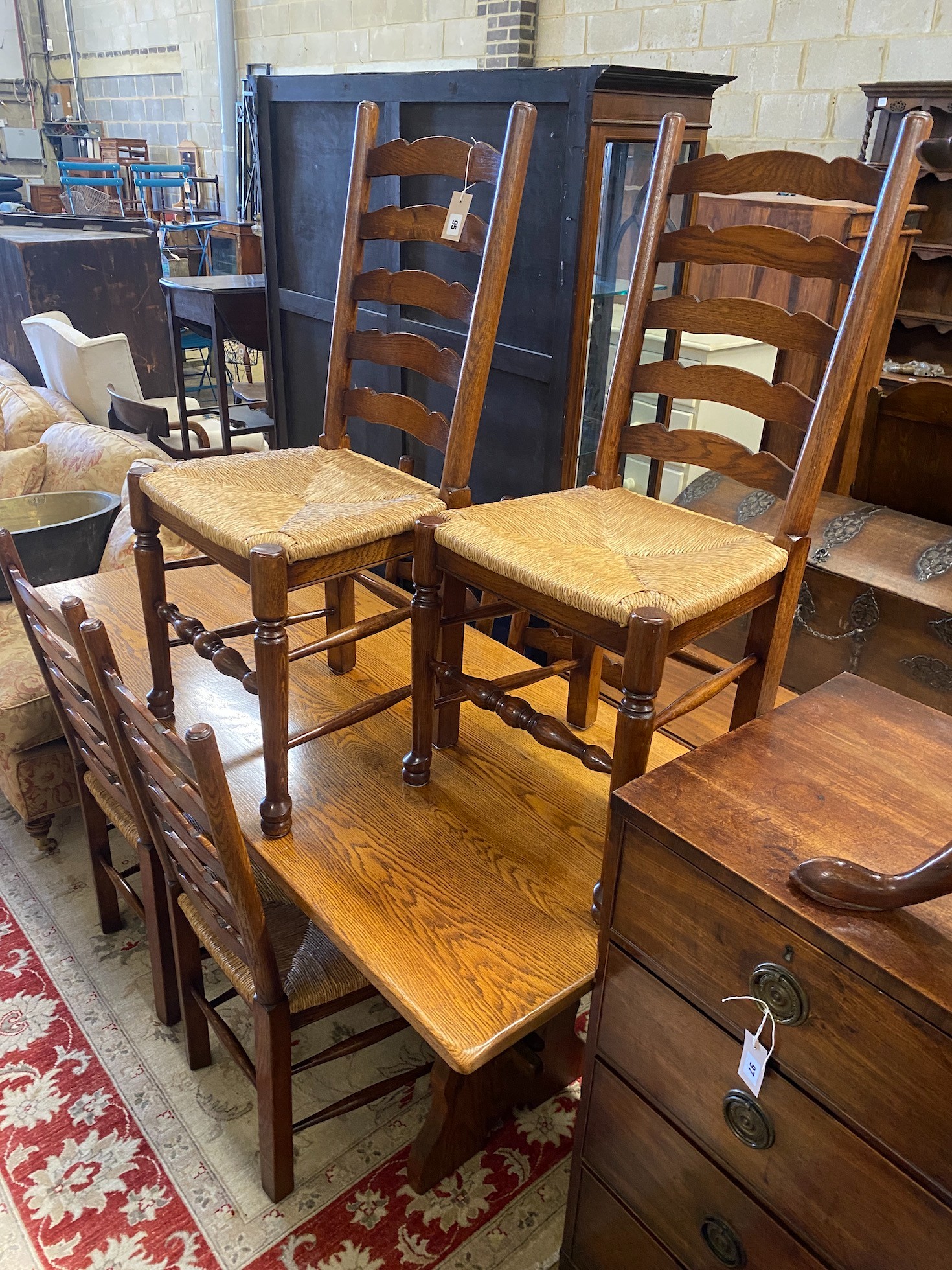 An 18th century style rectangular oak refectory dining table, length 167cm, depth 78cm, height 74cm and six ladderback rush seat dining chairs